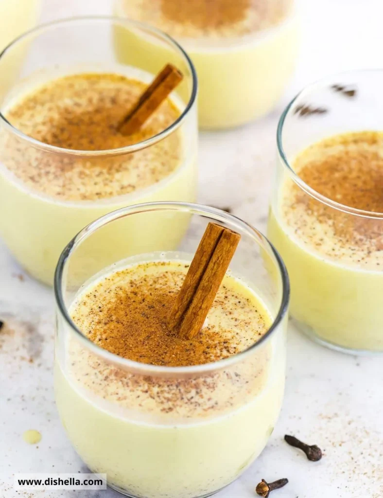 A glass of homemade eggnog garnished with cinnamon and nutmeg.