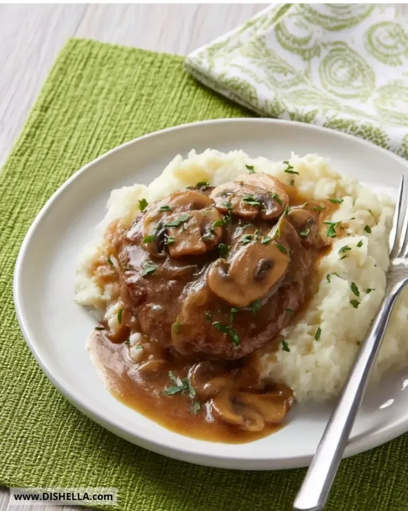 Hamburger steaks served with onion and mushroom gravy on a plate.