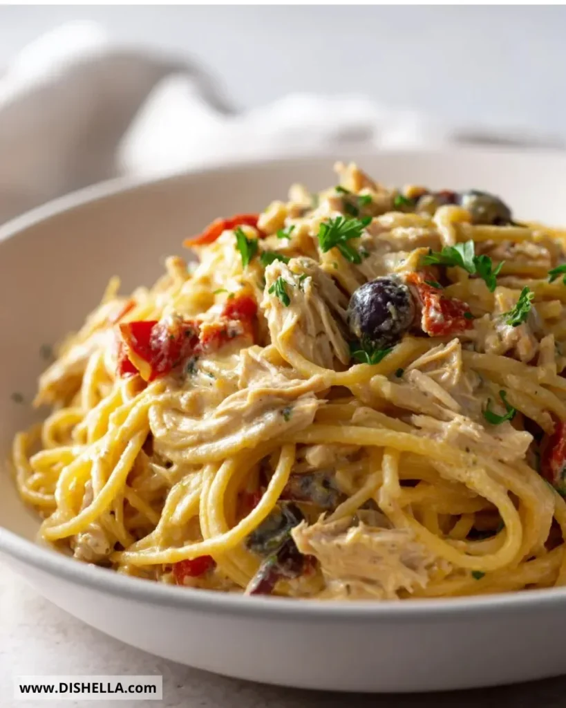 A bowl of classic Crockpot Chicken Spaghetti garnished with herbs.