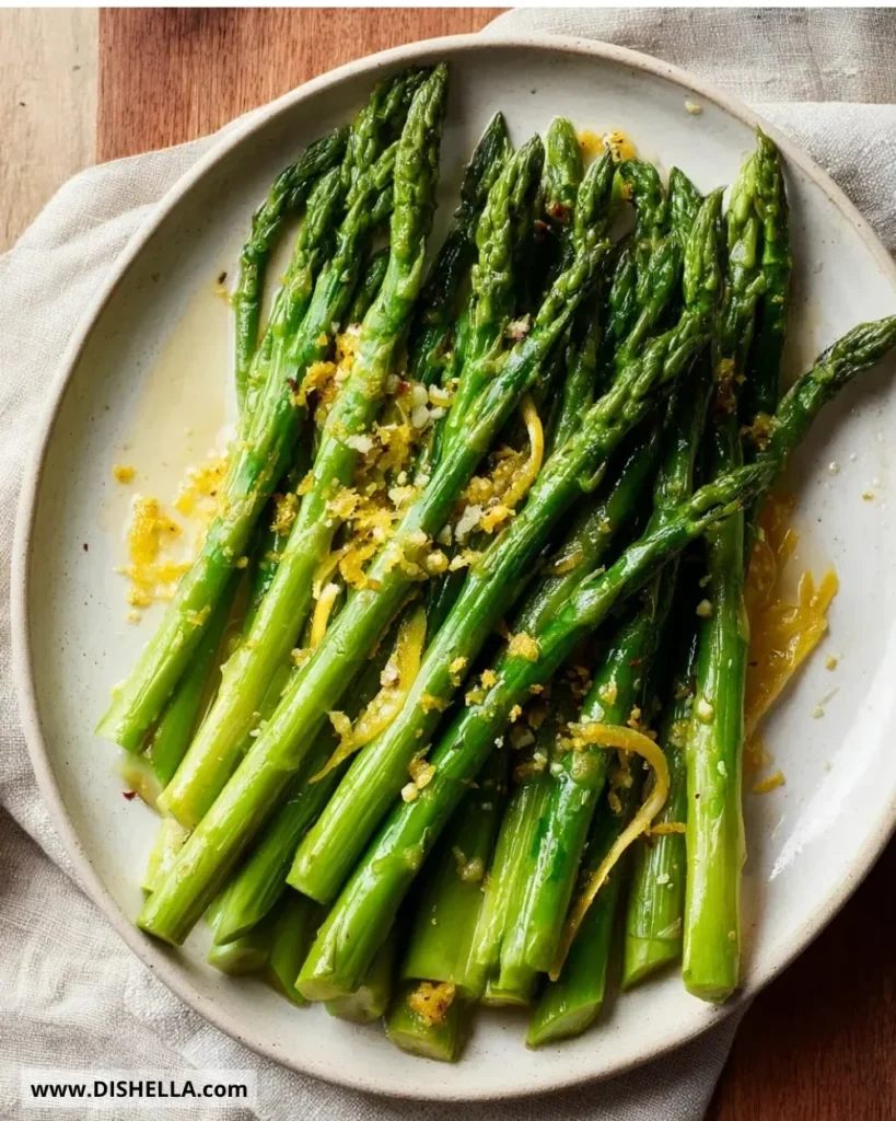 Crockpot Lemon Garlic Asparagus served on a plate with lemon garnish.