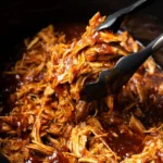 Delicious slow cooker BBQ pulled chicken served on a bun with slaw.