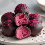 Decadent raspberry truffles with rich chocolate coating and fresh raspberries