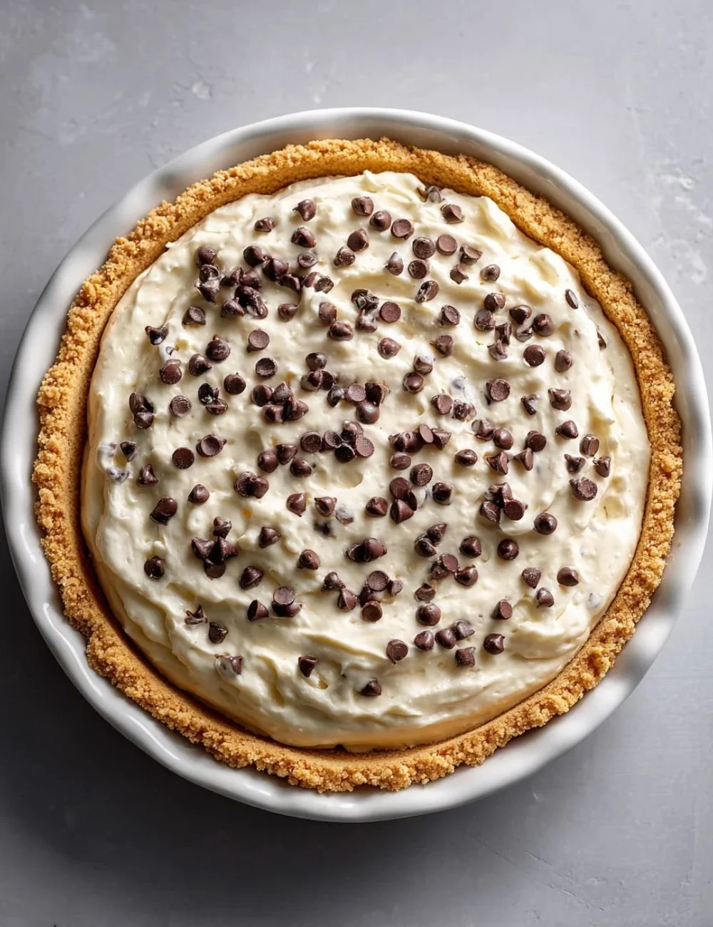 Slice of chocolate chip cannoli pie topped with chocolate chips and whipped cream