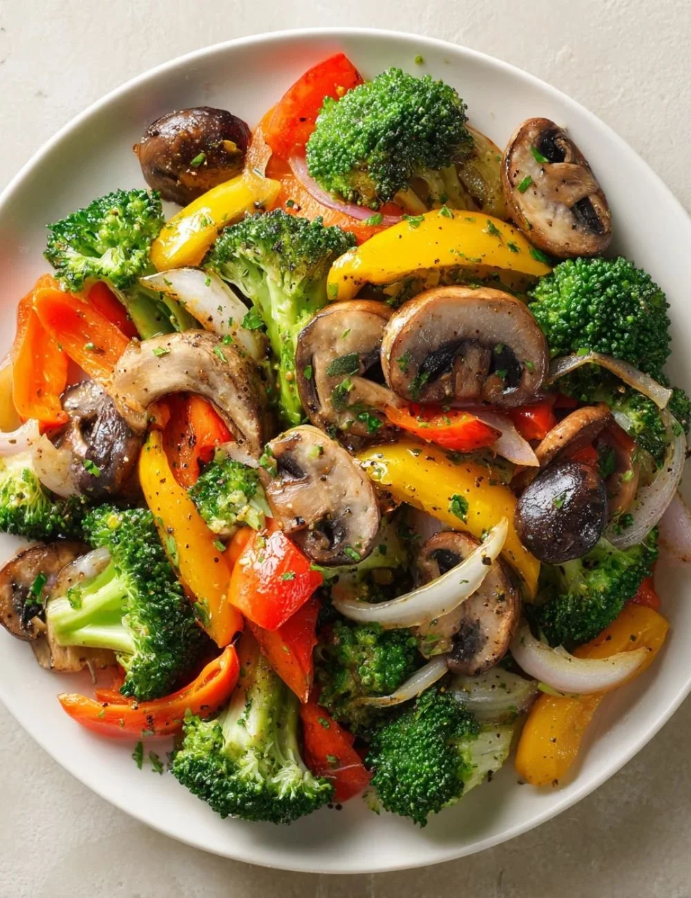 Bowl of colorful sautéed vegetables with garlic and herbs.