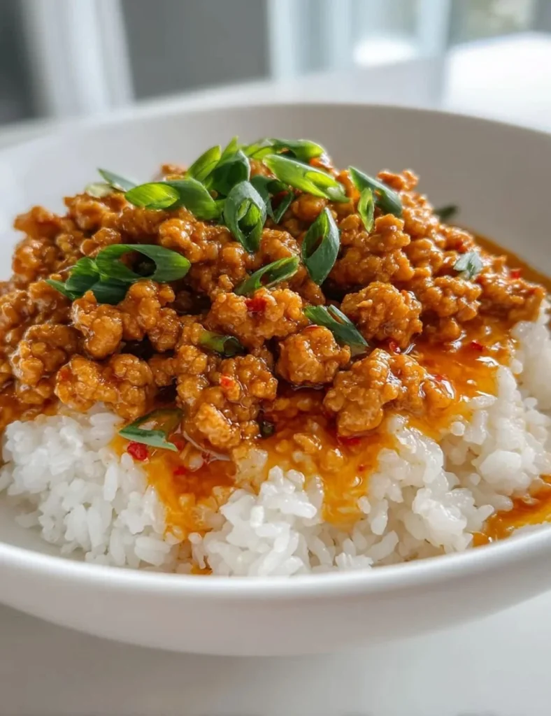 Delicious plate of Ground Orange Chicken with vibrant sauce and garnishes