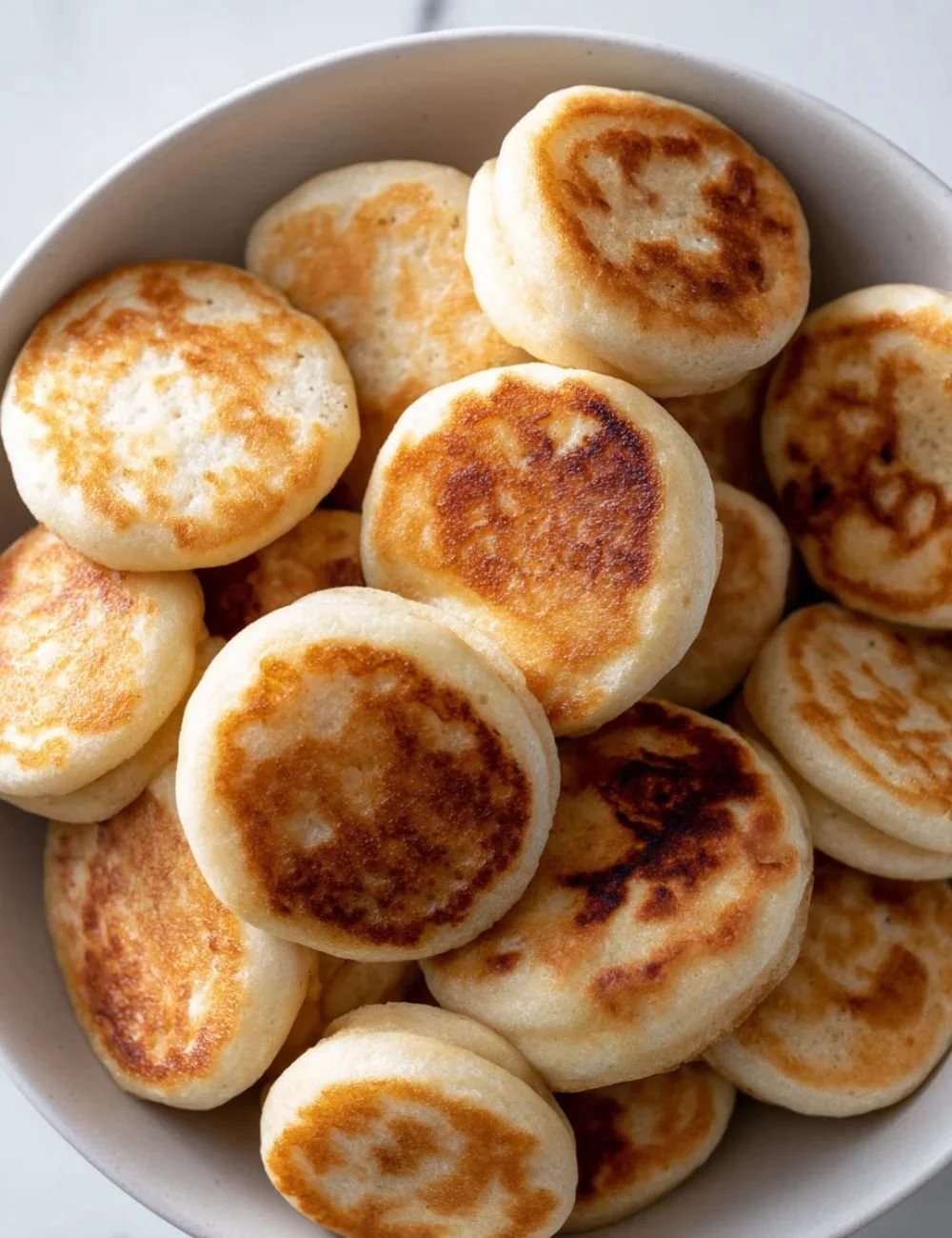Delicious pancake poppers served on a plate with syrup and fresh fruit