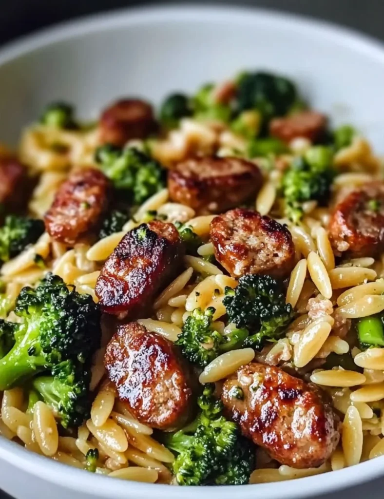 Chicken sausage and broccoli orzo dish served in a bowl