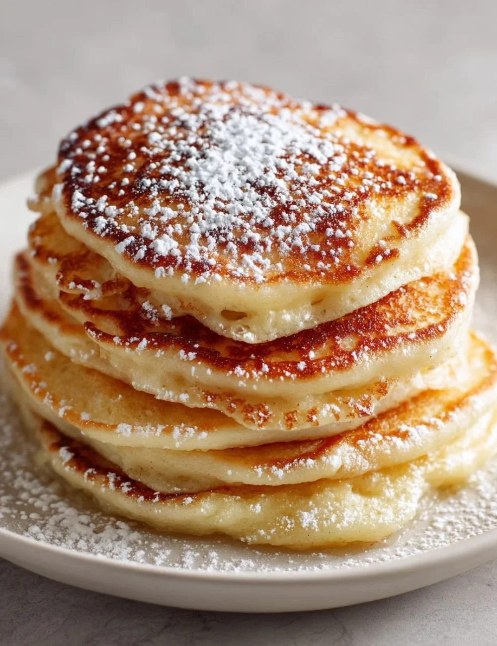 Fluffy Apple Yogurt Pancakes stacked on a plate with apple slices