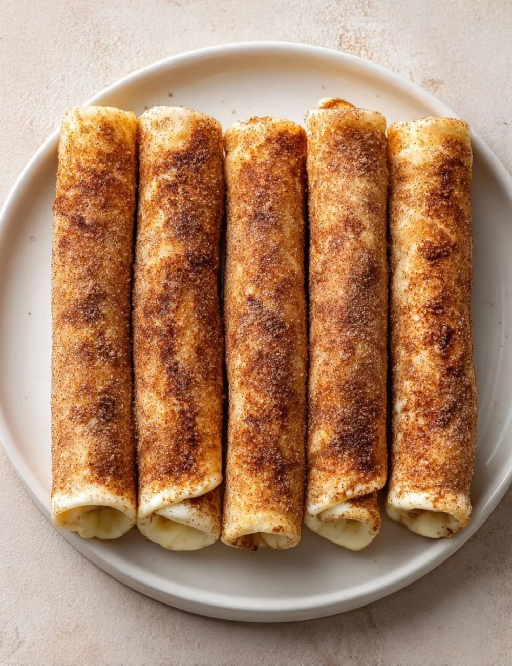 Keto Crispy Cinnamon Cream Cheese Roll Ups on a plate, golden and delicious