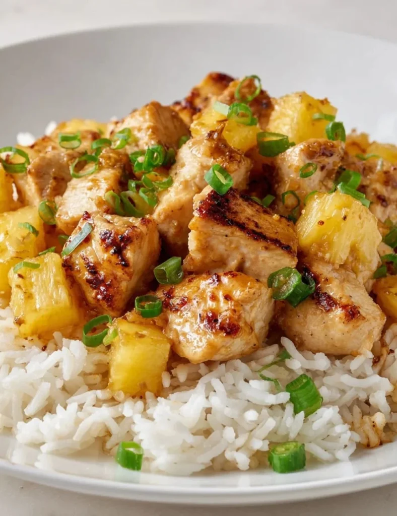 Pineapple Chicken and Rice dish garnished with fresh herbs on a plate