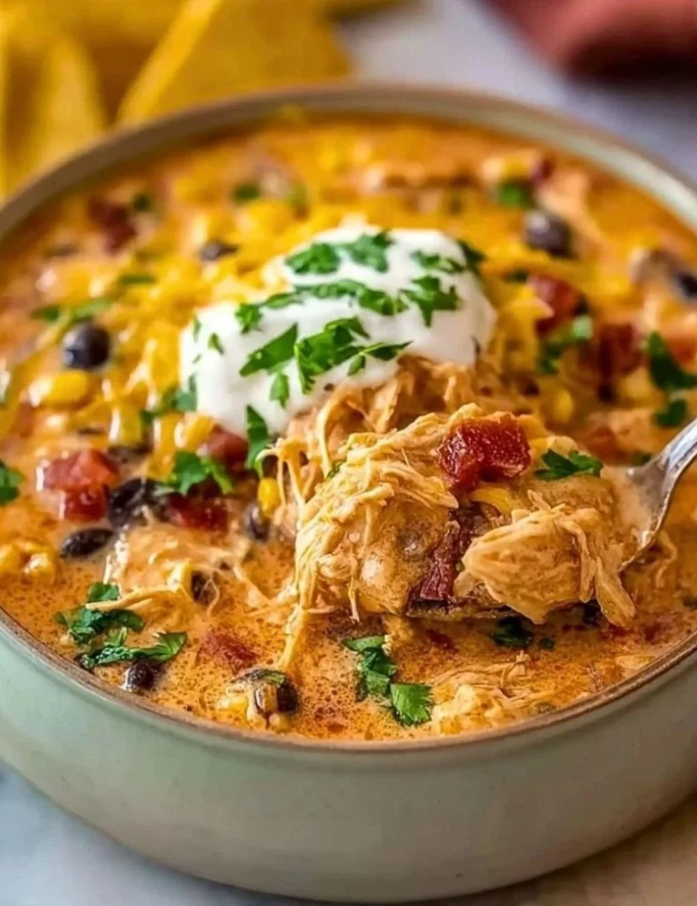 Bowl of classic slow cooker crack chicken chili topped with cheese and chives.