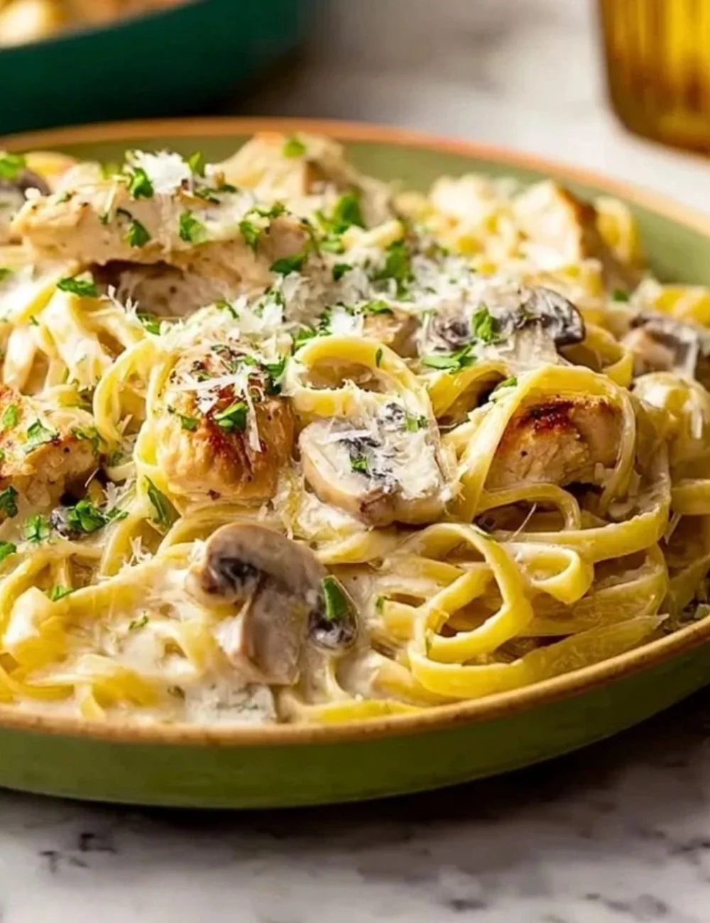 Creamy fettuccine Chicken Alfredo pasta dish garnished with parsley.