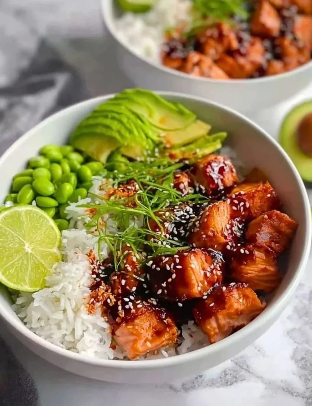 Flaky teriyaki salmon served in a bowl with colorful vegetables and rice