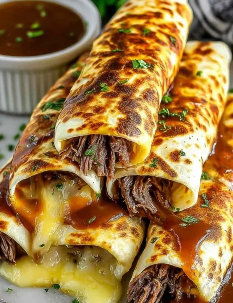 Delicious French Dip Tortilla Roll Ups served with au jus for dipping