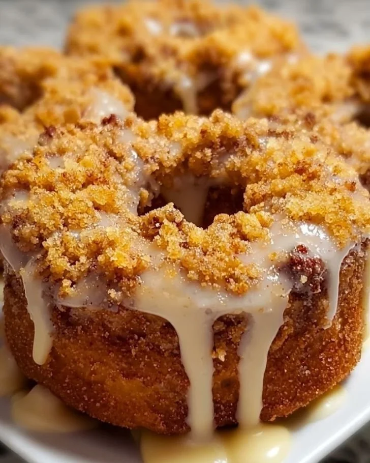 Baked coffee cake donuts with vanilla glaze on a plate