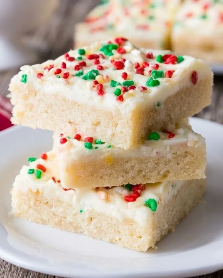 Plate of festive Christmas sugar cookie bars topped with colorful sprinkles