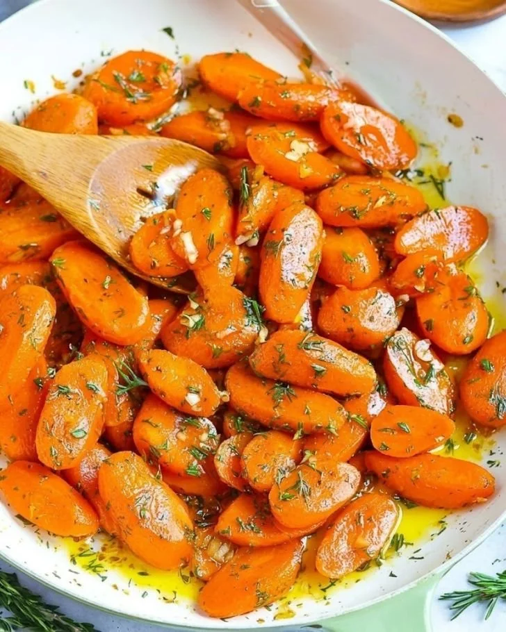 Easter garlic herb carrots garnished with fresh herbs and spices.